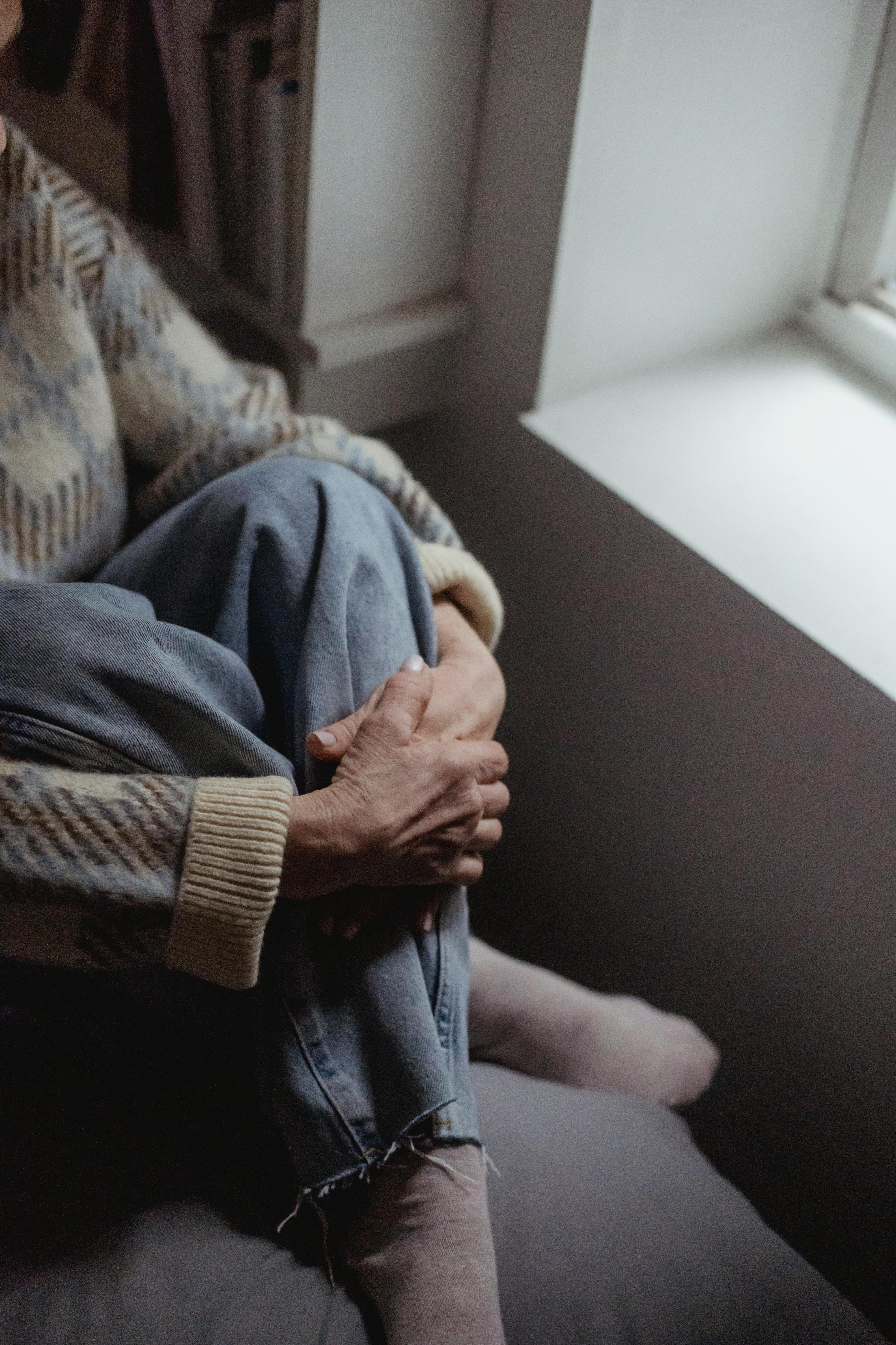 unrecognizable woman sitting near window