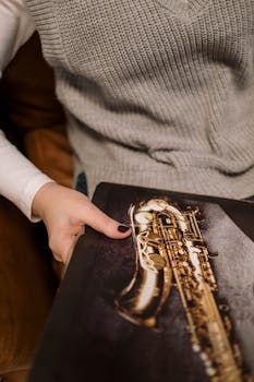 A person holding a vinyl album with a saxophone image, conveying a musical theme.