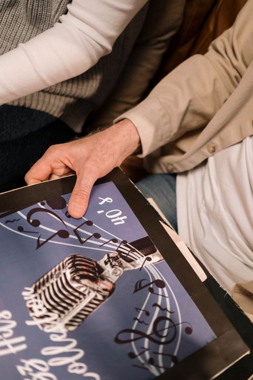 Free Close-up of hands holding a vintage vinyl record with a retro microphone design. Ideal for music themes. Stock Photo