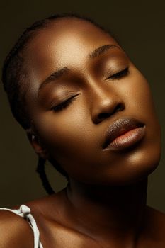 Artistic close-up portrait of a serene woman with closed eyes in a studio setting.
