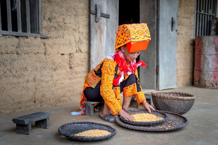 Person In Traditional Clothes With Food Outside