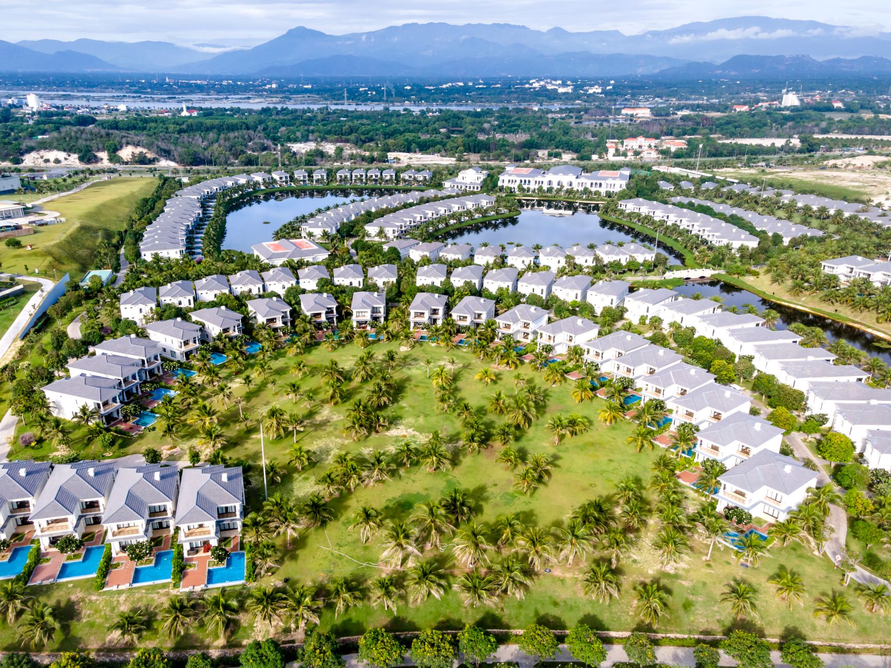 Aerial view of luxury resort community with villas and lush green landscape.