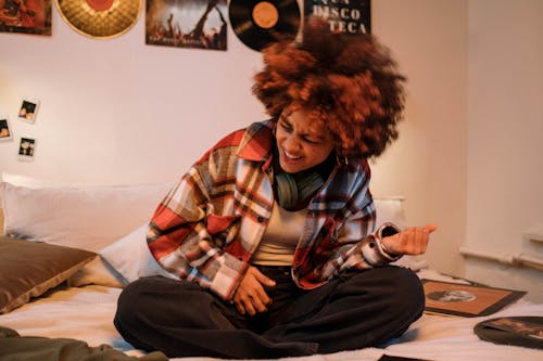 Free Woman Listening to Music in Her Bedroom Stock Photo