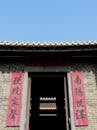 Traditional Asian house facade with hieroglyphs under cloudless blue sky