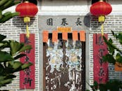 Exterior of old Chinese house with hieroglyphs and red paper lanterns