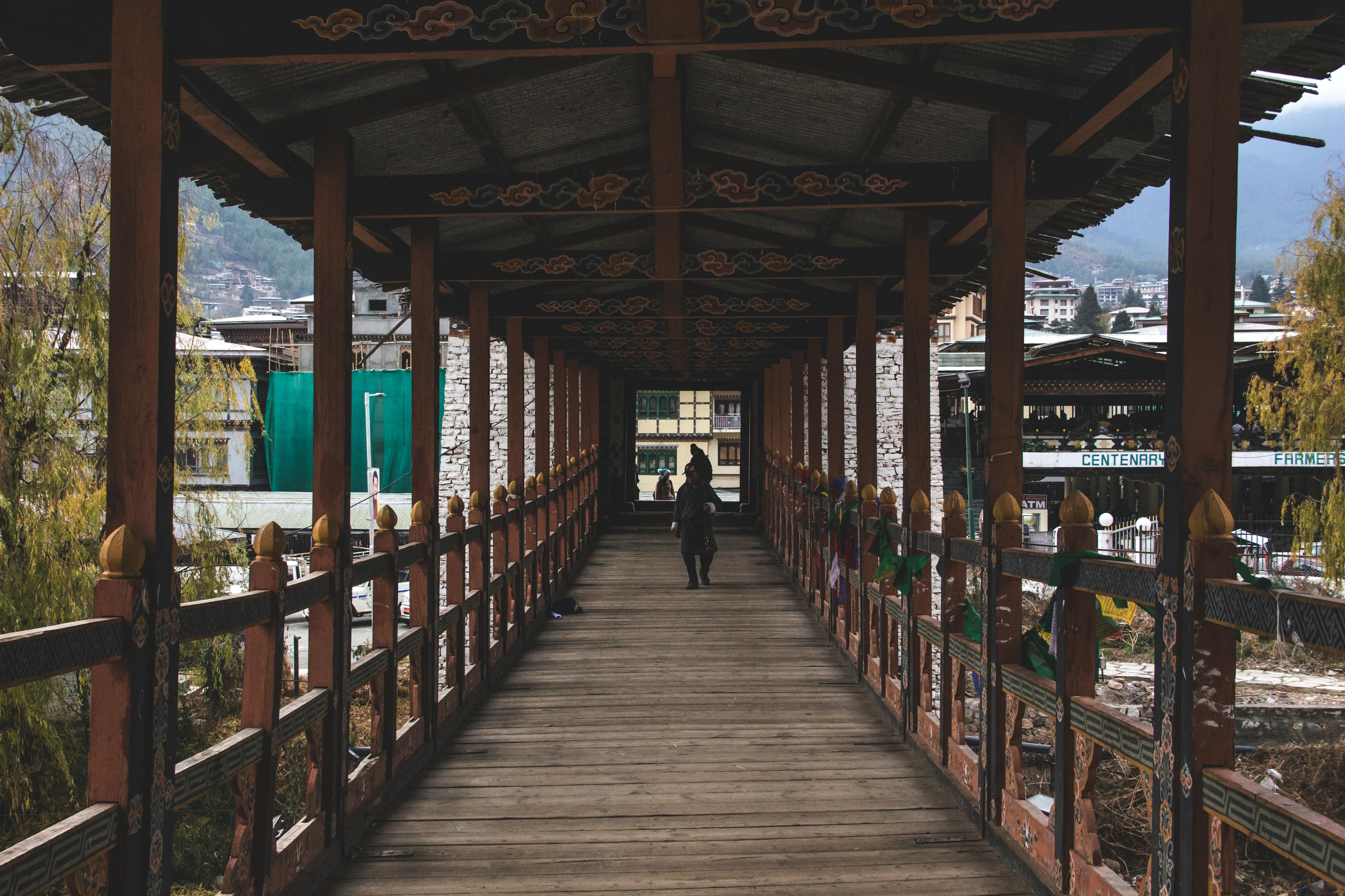 Person in Black Jacket Walking on Wooden Bridge · Free Stock Photo