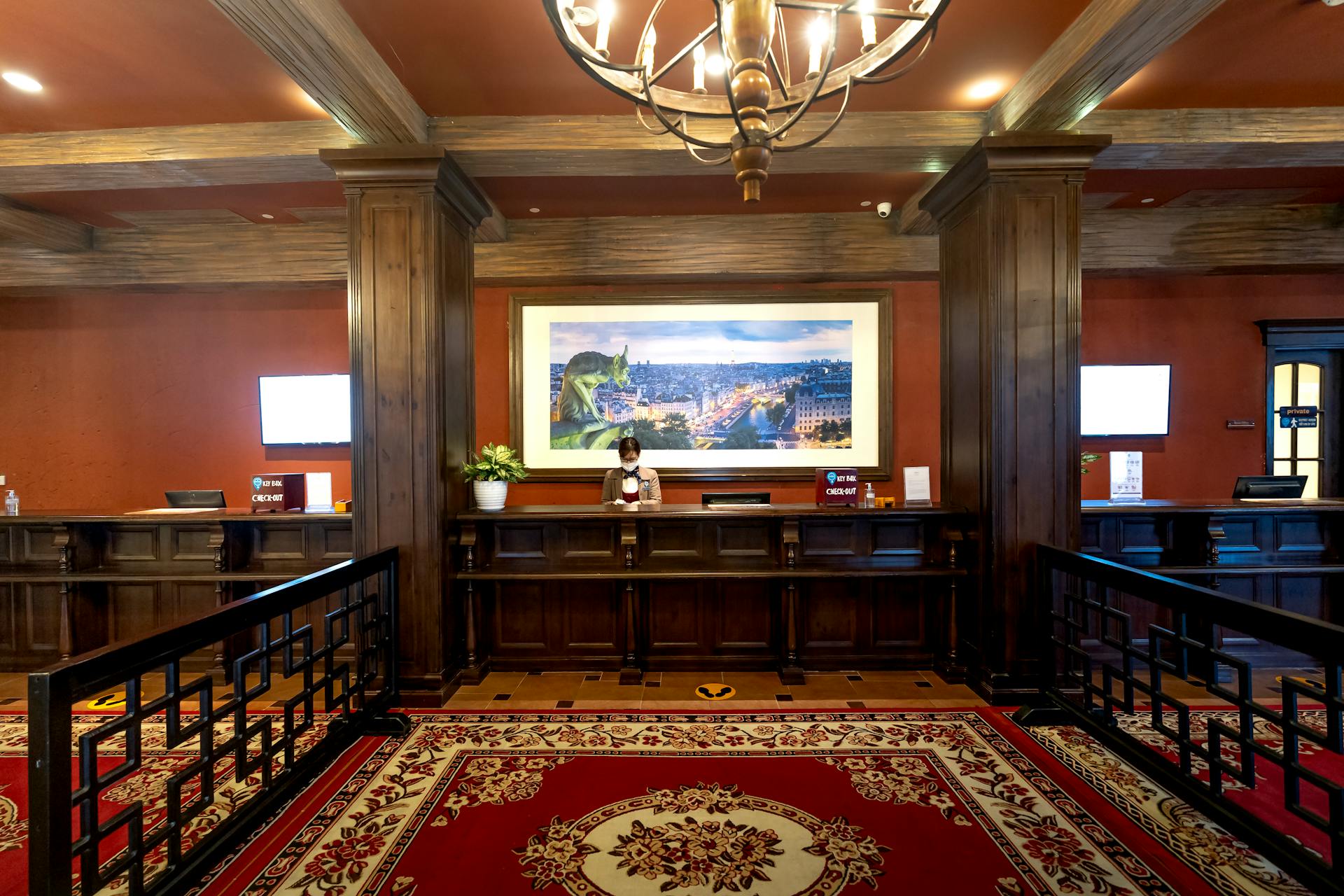 Elegant hotel lobby showcasing a receptionist at the front desk under warm lighting.