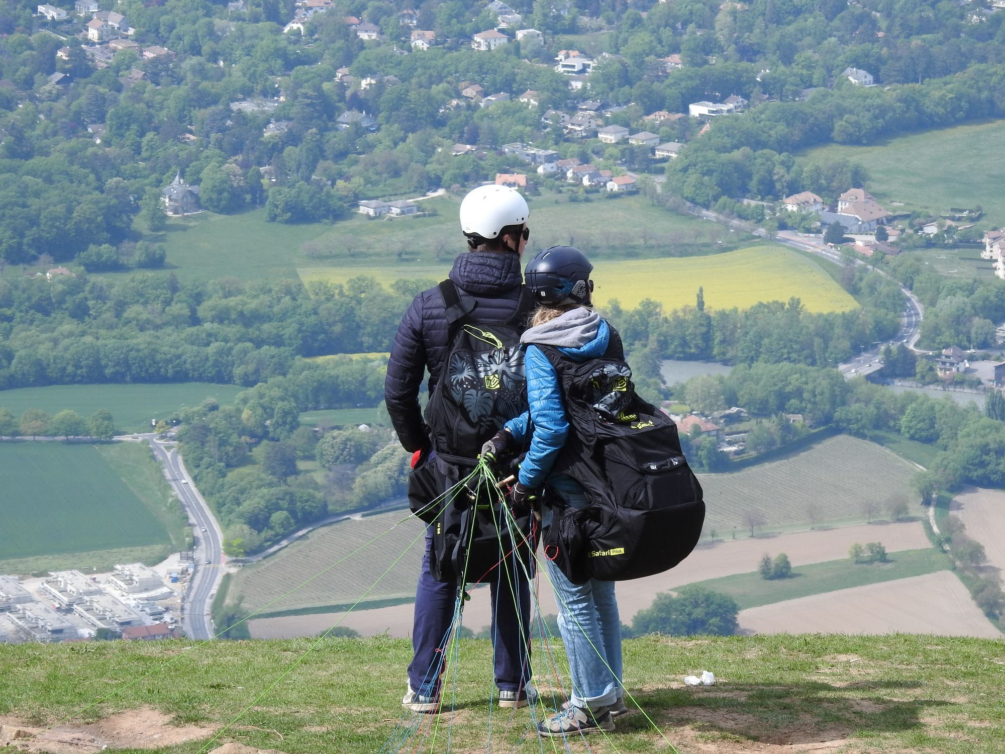 Couple ready for paragliding adventure with scenic view in Beaumont, France.