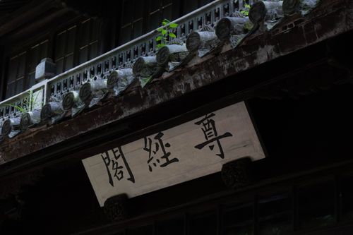 Free Close-up of traditional Asian architectural detail featuring stone roof and signage. Stock Photo