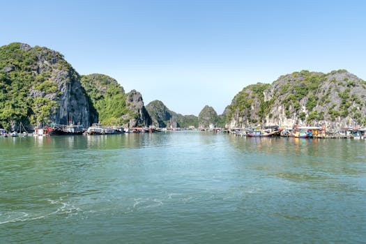 Capture of fishing boats and limestone formations in Halong Bay, a popular tourist destination.