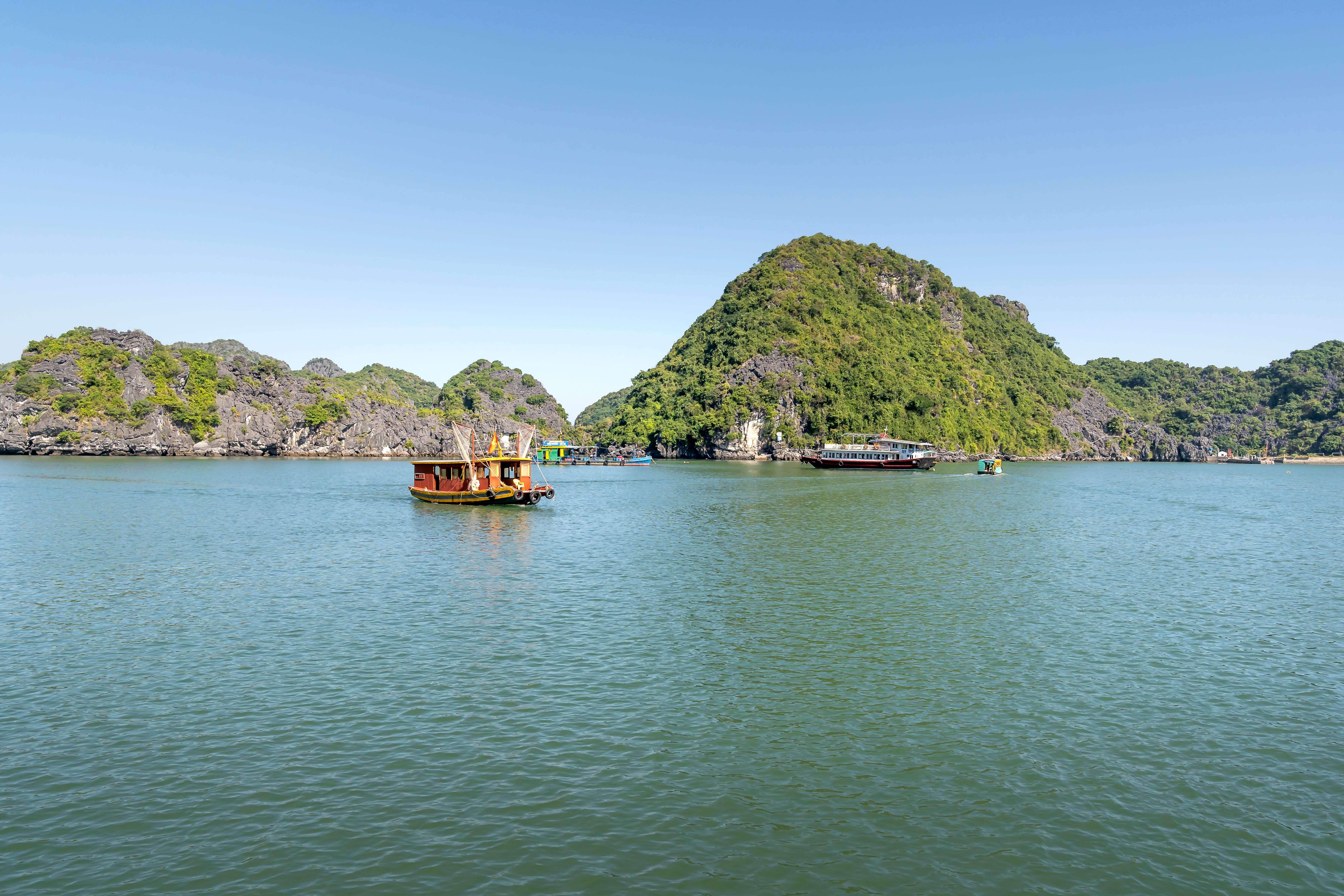 Boats sailing near green hills