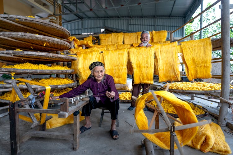 Elderly Woman And Man Preparing Yellow Fibers