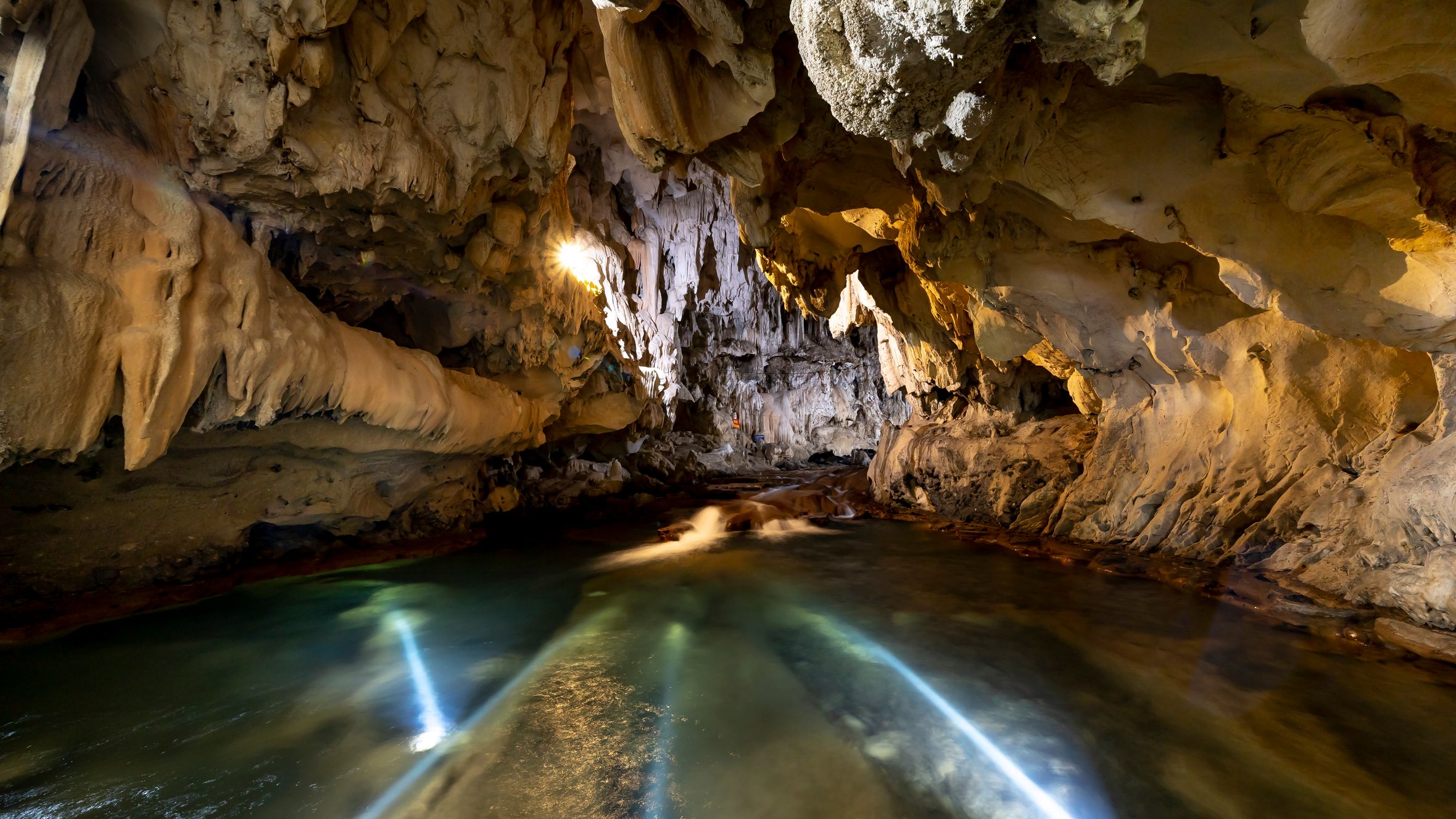 Explore a magnificent cave featuring unique rock formations and a serene underground river.