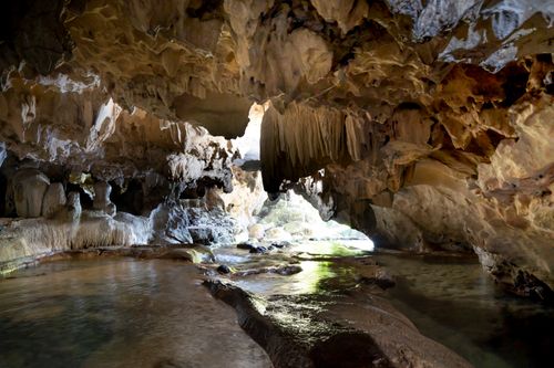 Free Explore a breathtaking cave with intricate rock formations and flowing water. Stock Photo