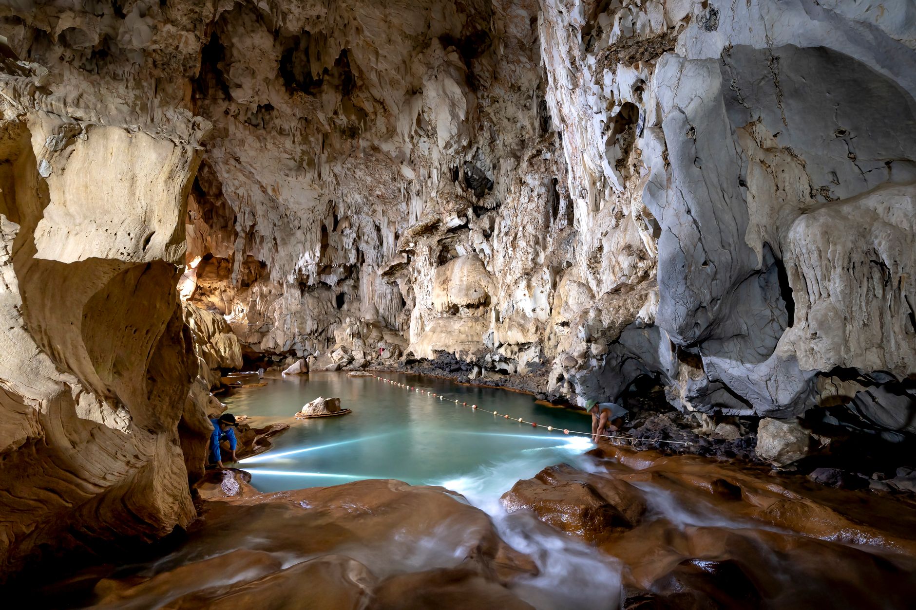 Explore the breathtaking beauty of a limestone cave featuring a crystal-clear lake with stunning stalactites.