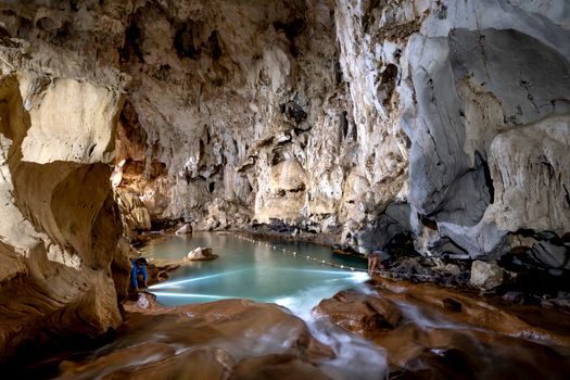 Explore the breathtaking beauty of a limestone cave featuring a crystal-clear lake with stunning stalactites.