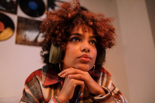 Woman in Red and White Plaid Shirt Using Black Headphones