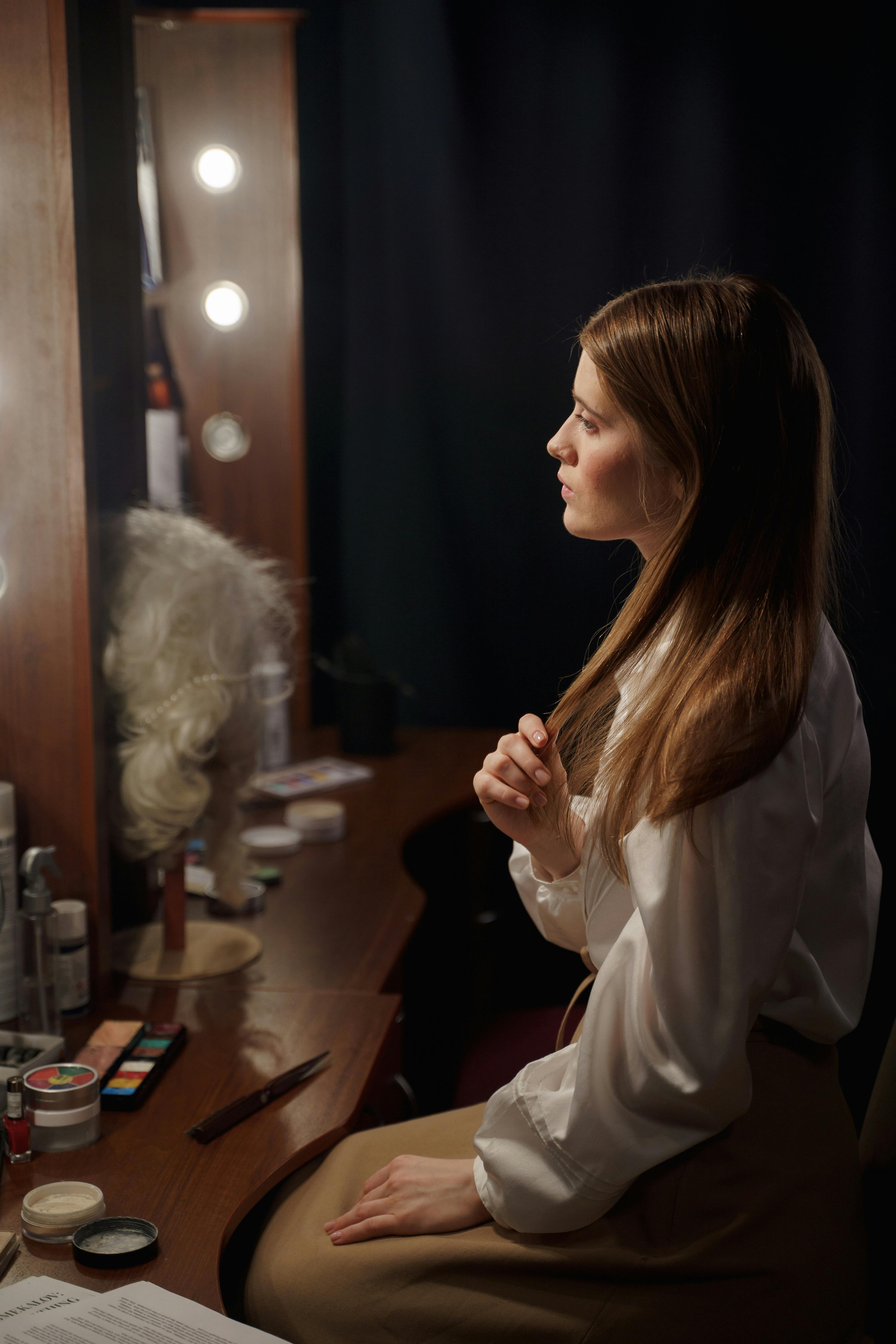 Woman in White Long Sleeve Shirt Sitting on Chair