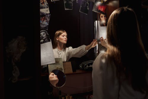 Woman Sitting In Front Of A Mirror Reading A Script