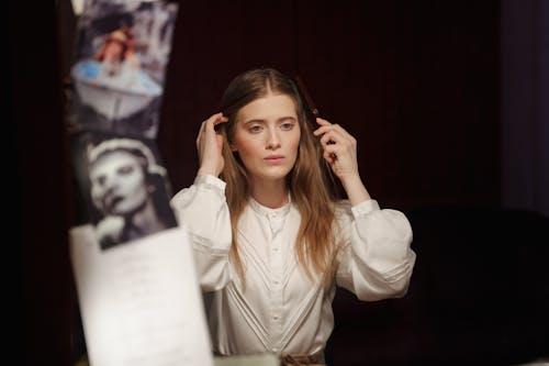 Woman in White Long Sleeve Shirt Holding Her Hair