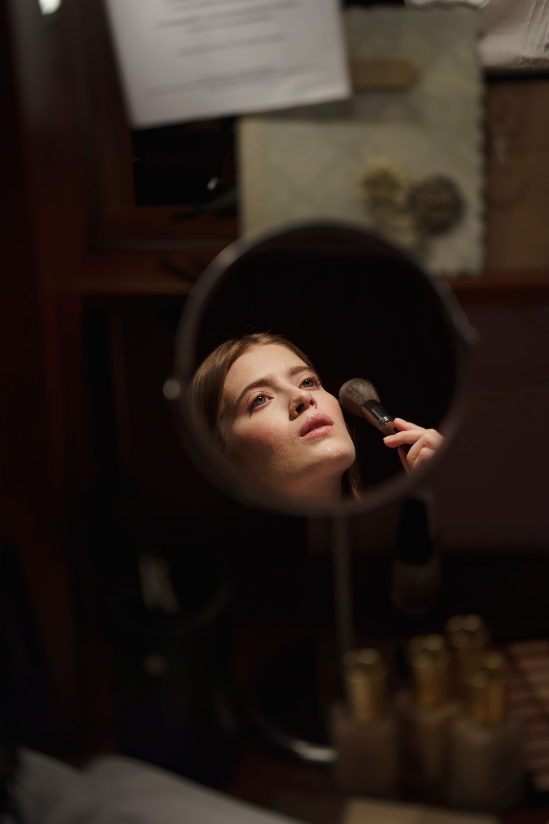 Com&eacute;dienne se maquillant devant le miroir d'une loge