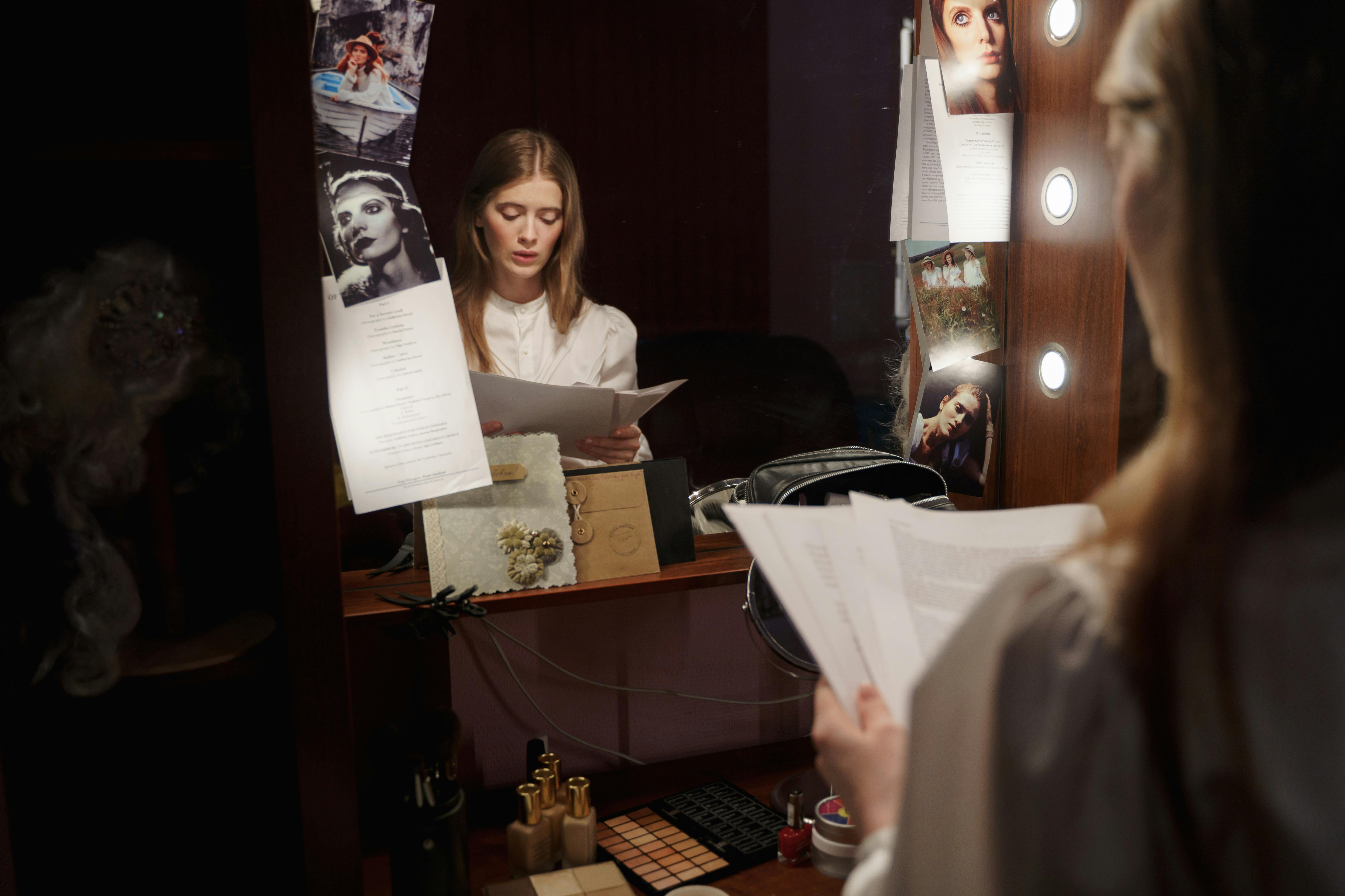 reflection of a woman in the mirror reading a script