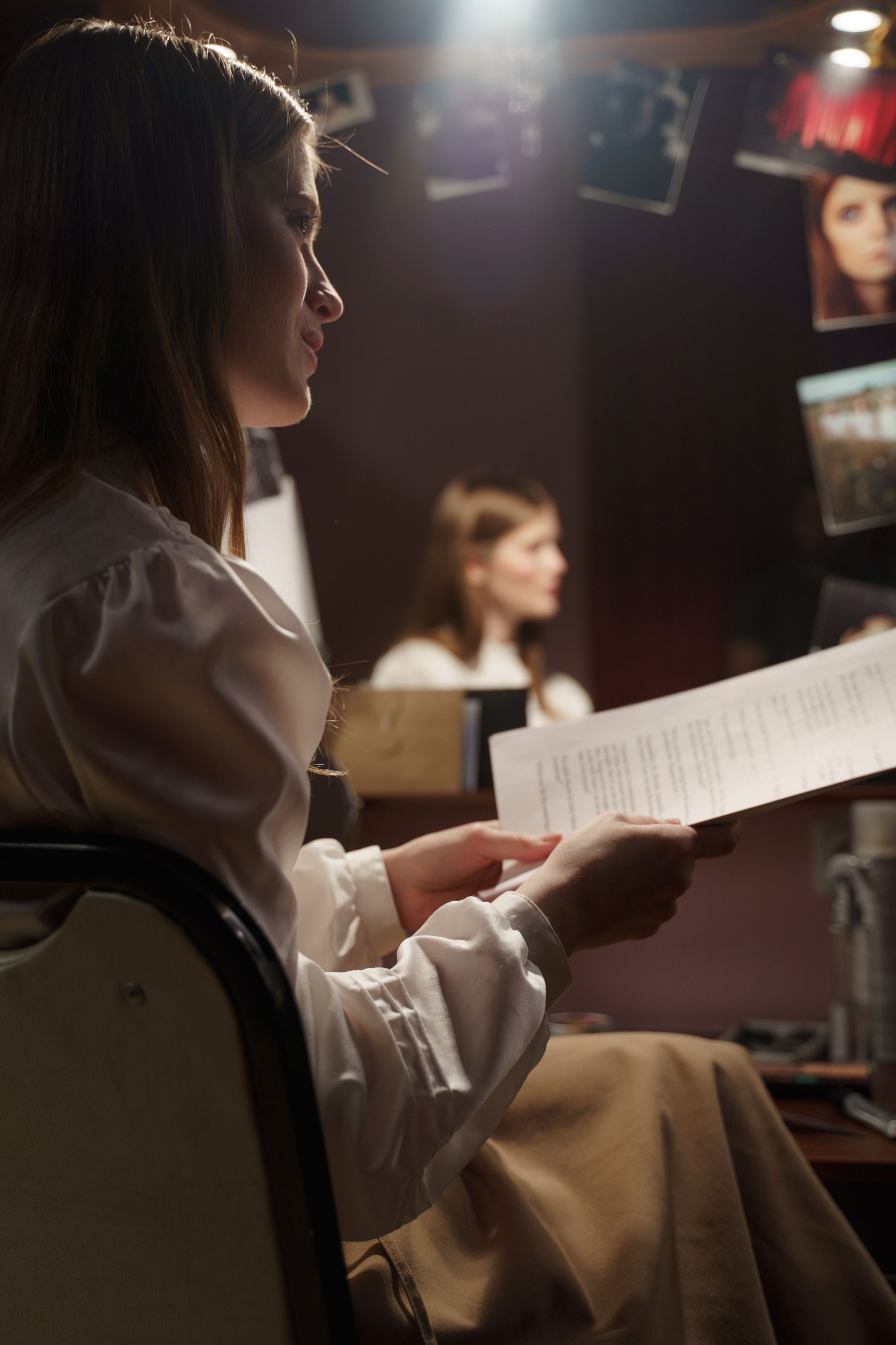 Com&eacute;dienne assise dans une loge avec son script devant un miroir