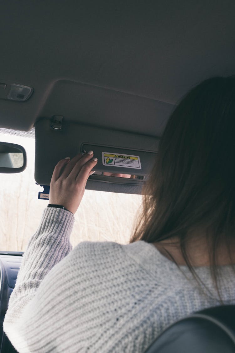 Woman Lowering Sun Visor In A Car