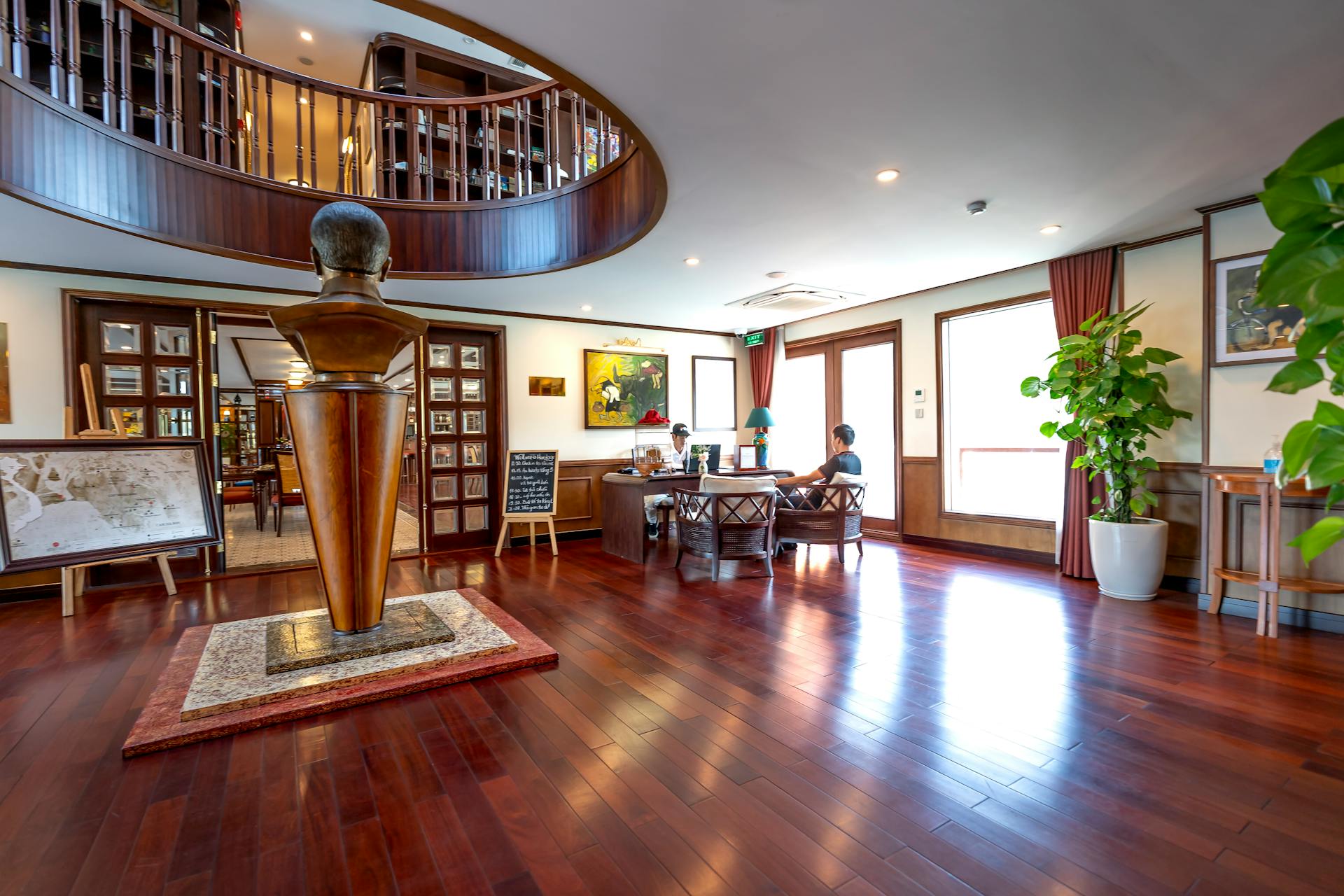 Elegant interior of a cruise ship with a wooden statue, seating area, and decor.