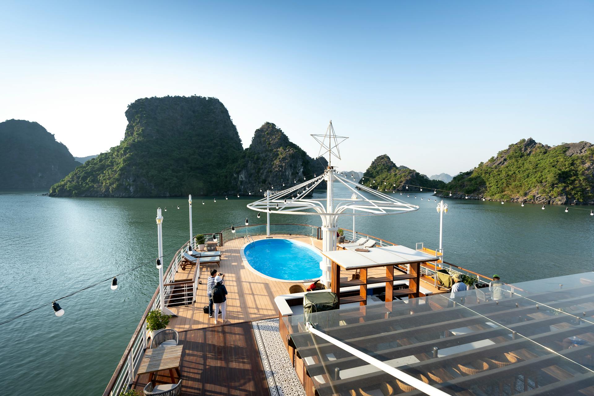 Experience luxury cruising with a scenic view of limestone karsts and onboard pool amenities.