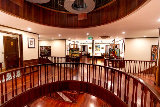Luxurious cruise ship interior featuring elegant staircases and vibrant artworks.