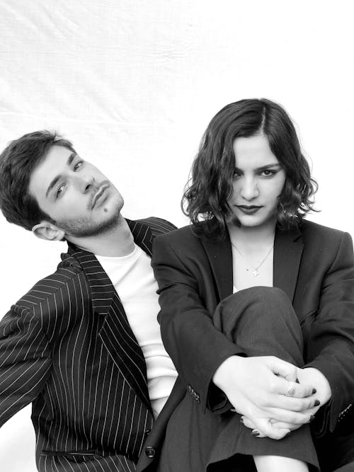 Monochrome Photograph of a Fashionable Couple Sitting Together