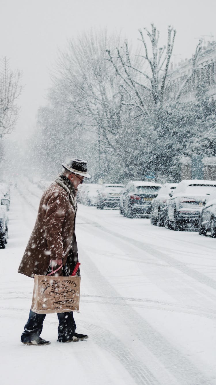 Photo Of An Elderly Man Walking On A Road During Winter