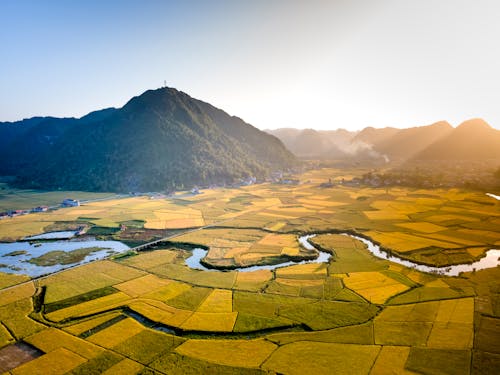 Aerial View of a Beautiful Landscape of Croplands and a River in a Valley 