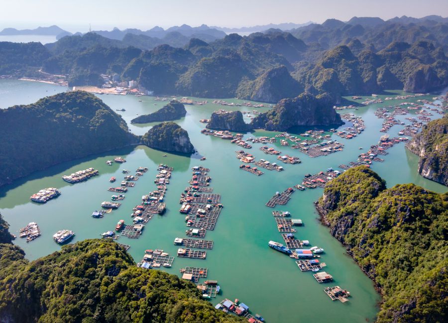 Stunning aerial shot of Ha Long Bay's turquoise waters and floating villages.