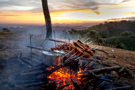 Delightful outdoor barbecue overlooking scenic hills during sunset. Perfect for travel and culinary inspiration.