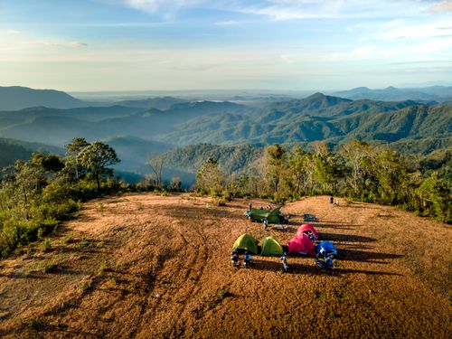 Free Aerial view of tents on a mountain with a stunning sunrise backdrop, perfect for adventure seekers. Stock Photo