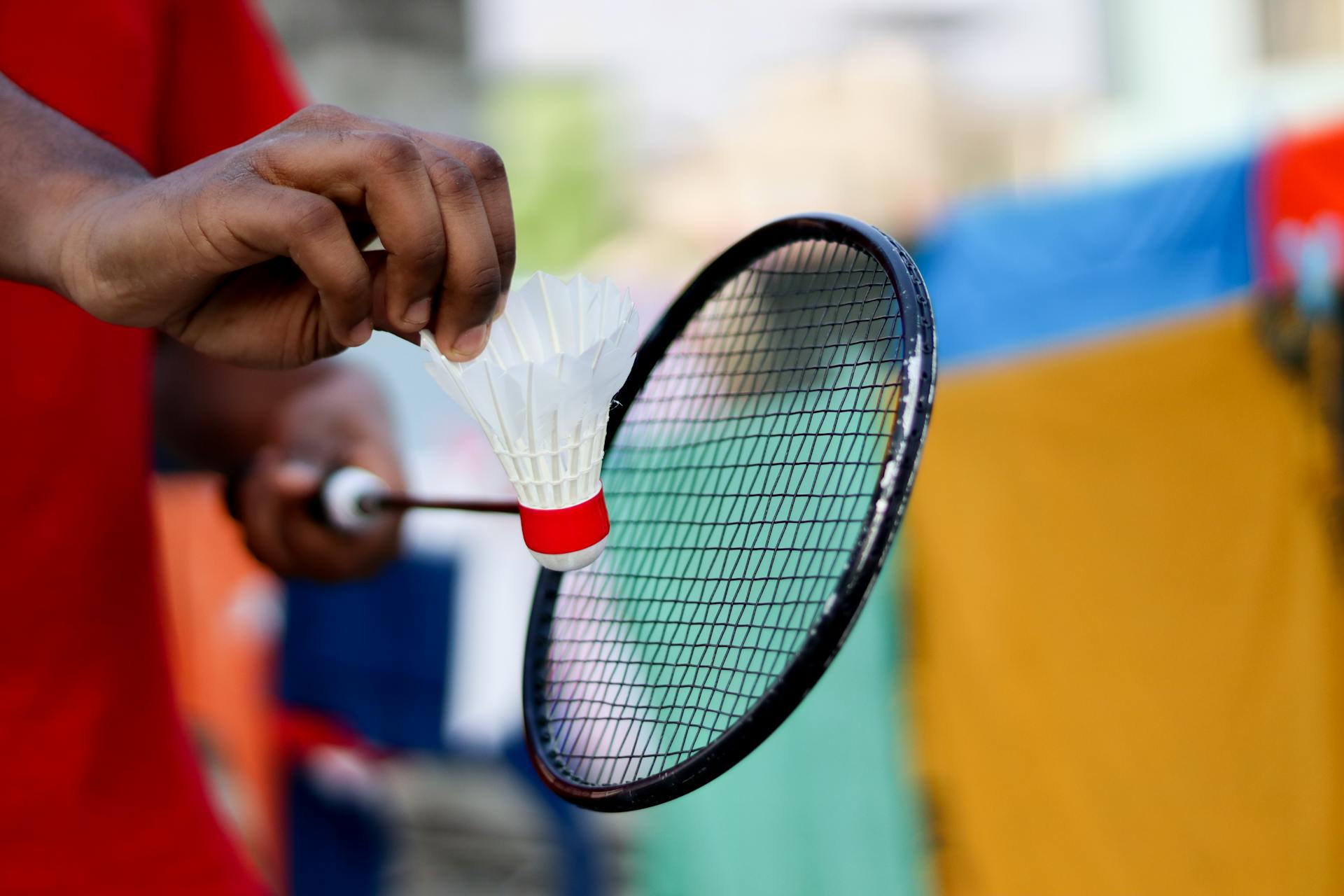 A Person's Hand Holding a Shuttlecock