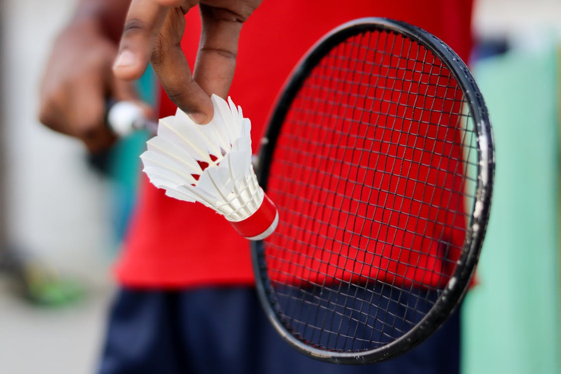 Photograph of a Person Holding a Shuttlecock