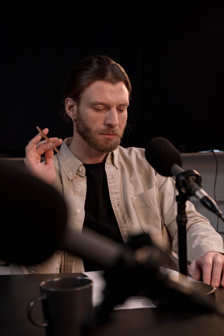 Photo Of A Man In A Beige Shirt Holding A Pen