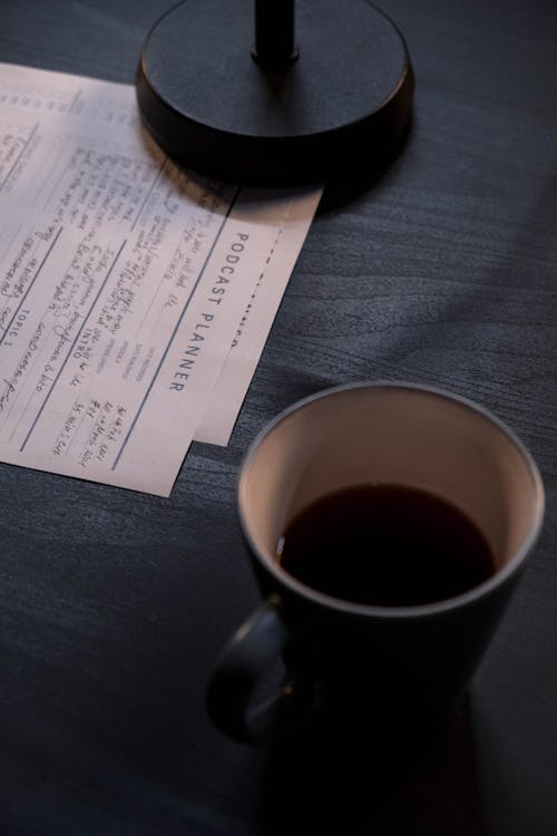 Papers Beside a Cup of Coffee