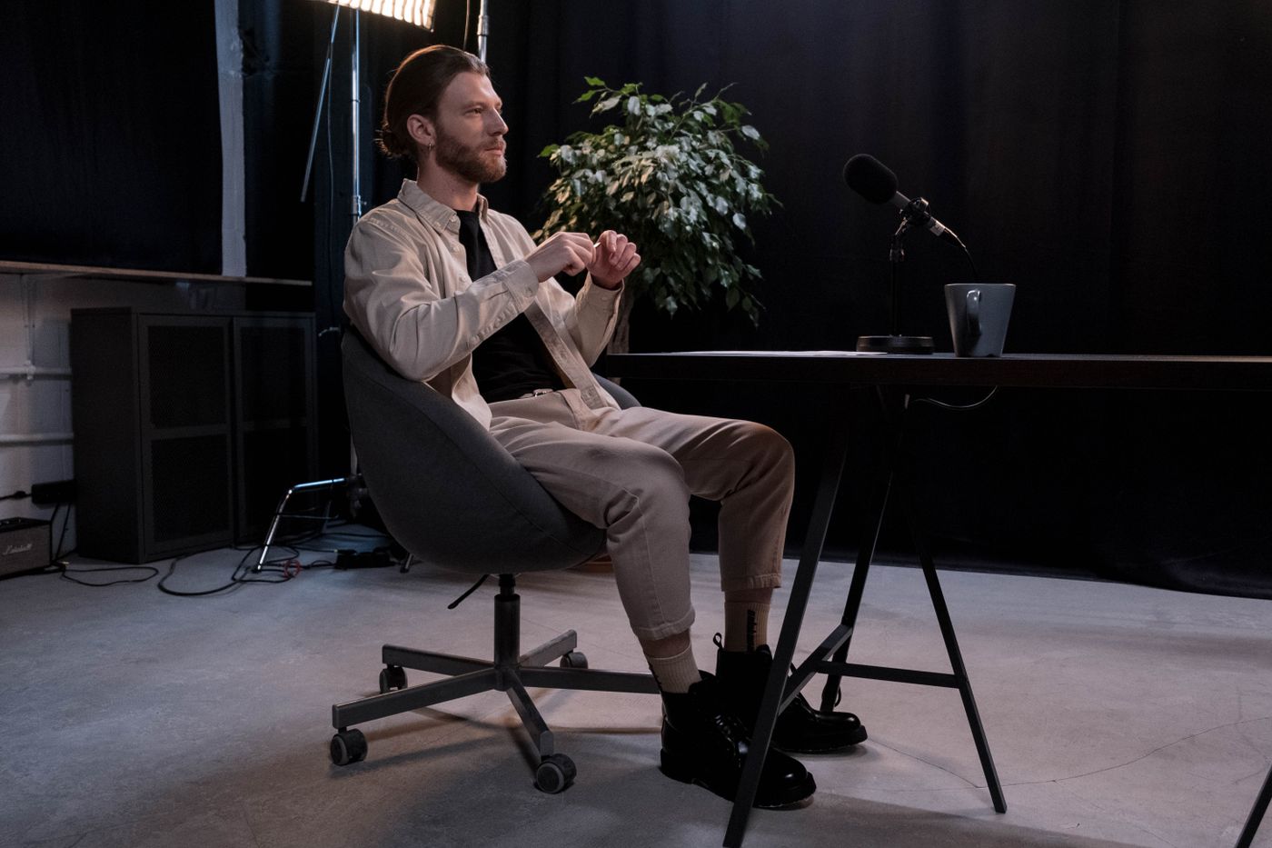 A founder seated mid-interview in a dark, plant-filled room — photo by cottonbro studio on Pexels
