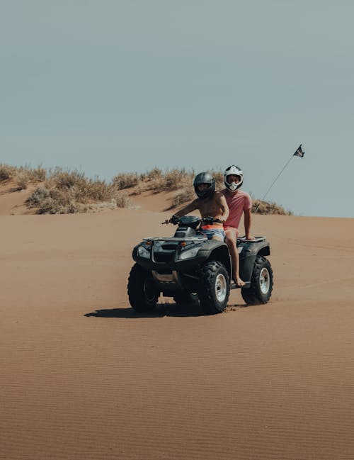 Men Riding Black and Gray ATV on Brown Sand