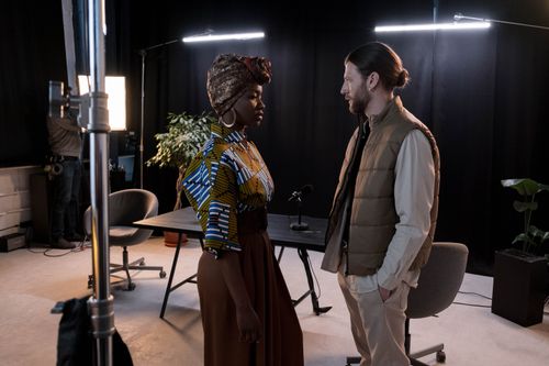 Free Diverse models in a fashionable studio setup with lighting equipment and a table. Stock Photo