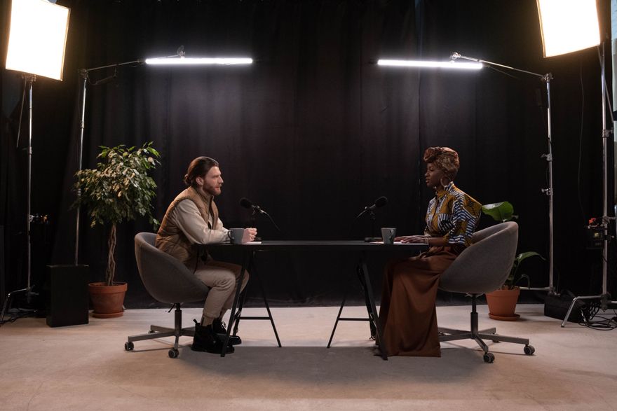 Two hosts recording in a lit studio set — photo by cottonbro studio on Pexels