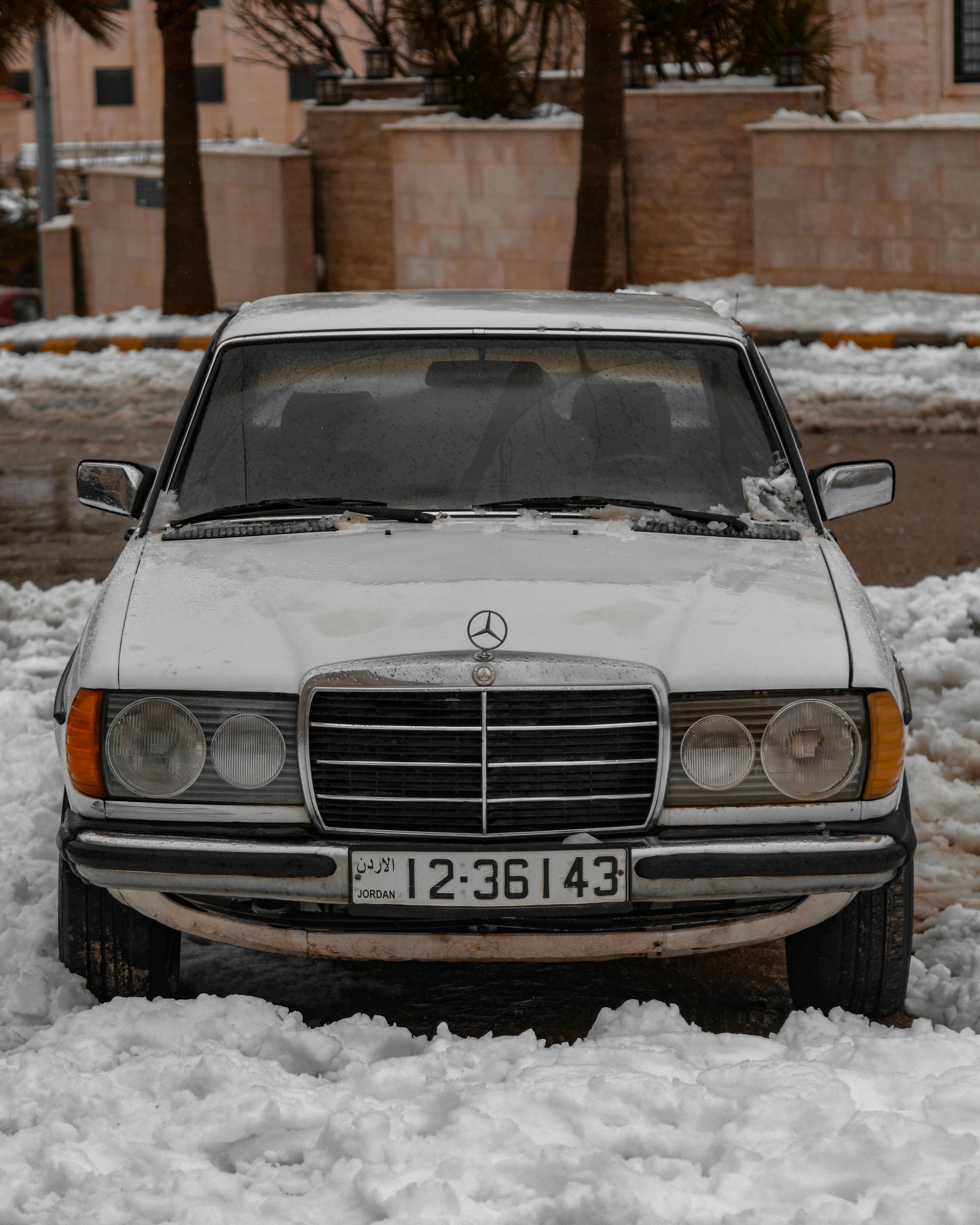 white mercedes benz parked on the snow