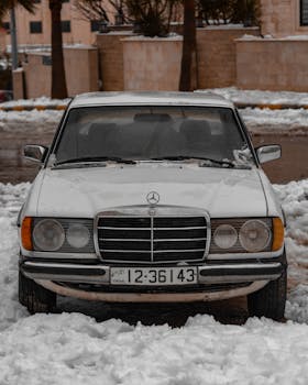 Vintage Mercedes-Benz car parked in snowy Amman, capturing winter scene in Jordan.
