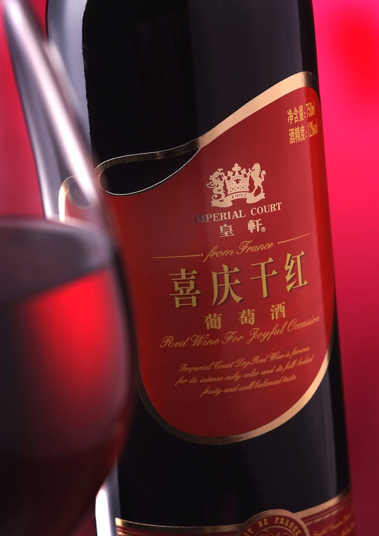 Close Up Of A Red Whine Bottle With Chinese Script Label