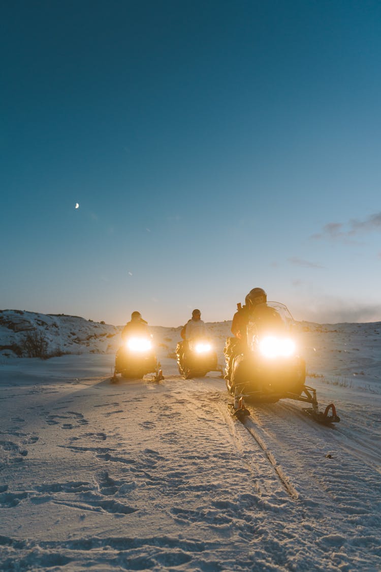 People Riding Snowmobiles