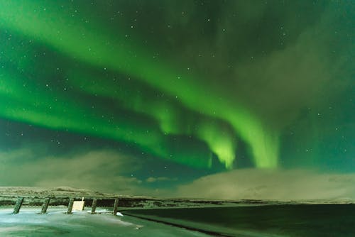 A Snow Covered Ground Under the Aurora Borealis at Night